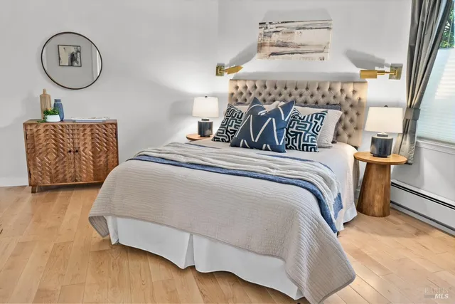 a bedroom with a bed and a lamp on dresser