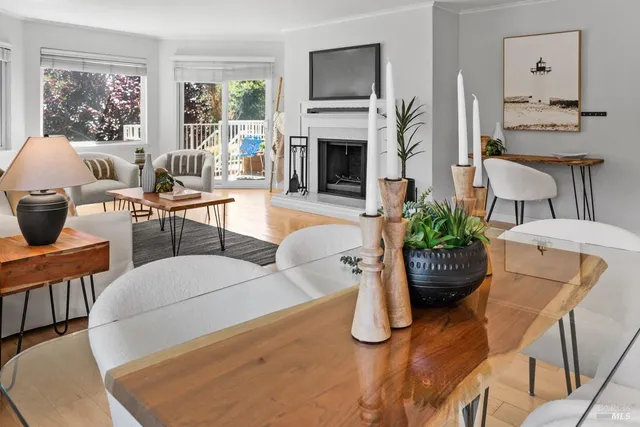 a living room with furniture a fireplace and potted plants
