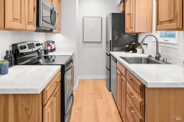 a kitchen with stainless steel appliances granite countertop a sink a stove and a refrigerator