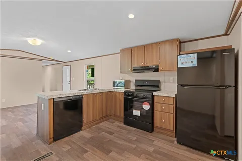a kitchen with stainless steel appliances granite countertop a sink stove and cabinets