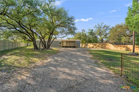 a view of a yard with wooden fence