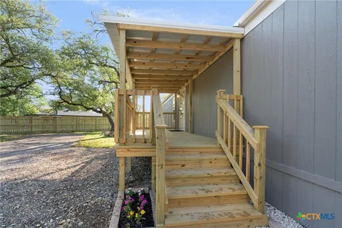 a view of a pathway of a house with wooden floor and fence