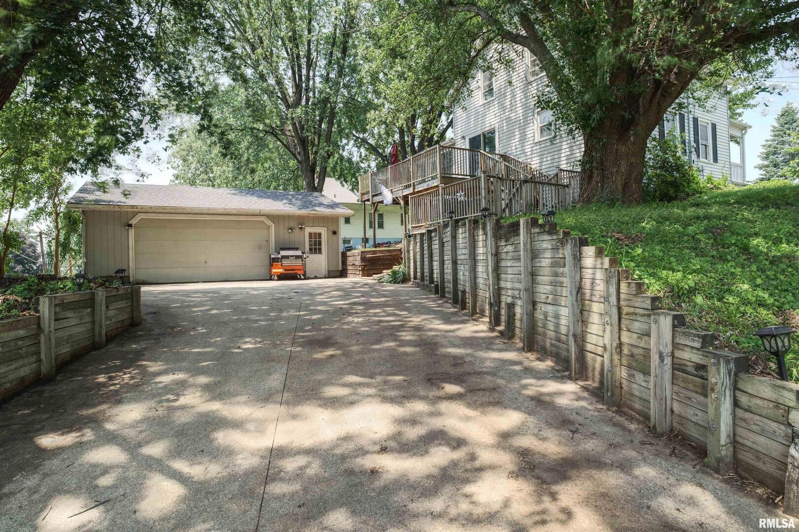 828 10th Avenue Fulton, IL 61252 - Photo 31 of 34 a view of a house with a small yard plants and a large tree