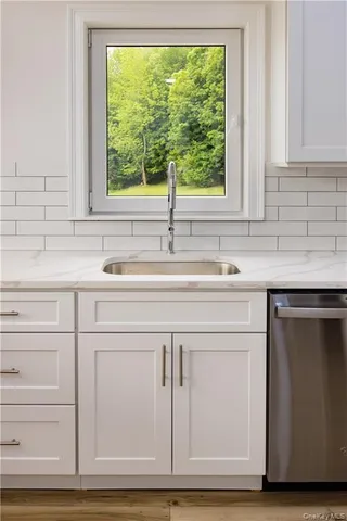 a view of a hallway with two windows and a couch