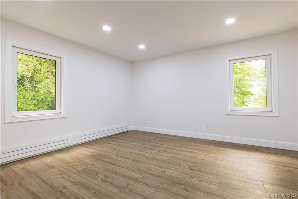 274 Reservoir Hill Road Norwich, NY 13815 - Photo 18 of 44 an empty room with wooden floor and windows