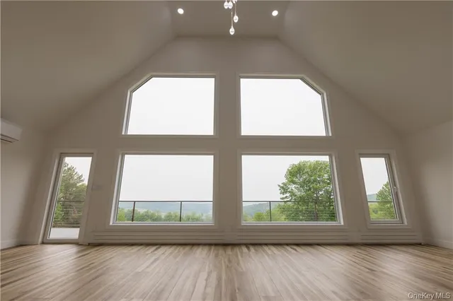 an empty room with wooden floor and a window