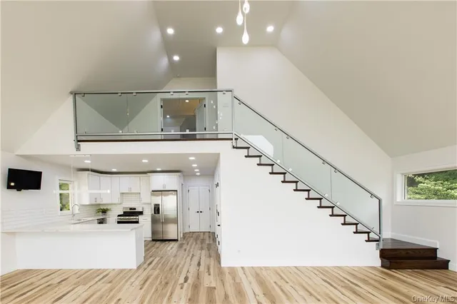 a view of entryway and kitchen with wooden floor