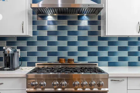 a view of a kitchen with stainless steel appliances granite countertop a stove and a sink