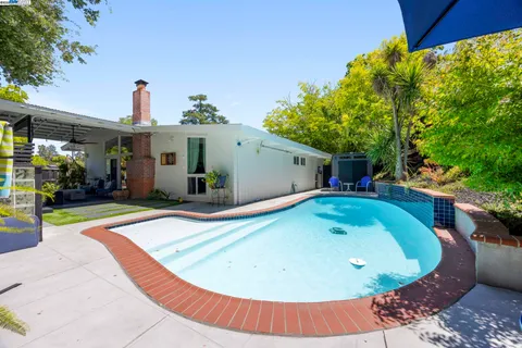 an aerial view of green landscape with trees houses and mountain view