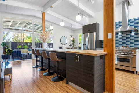 a kitchen with a sink appliances and wooden floor