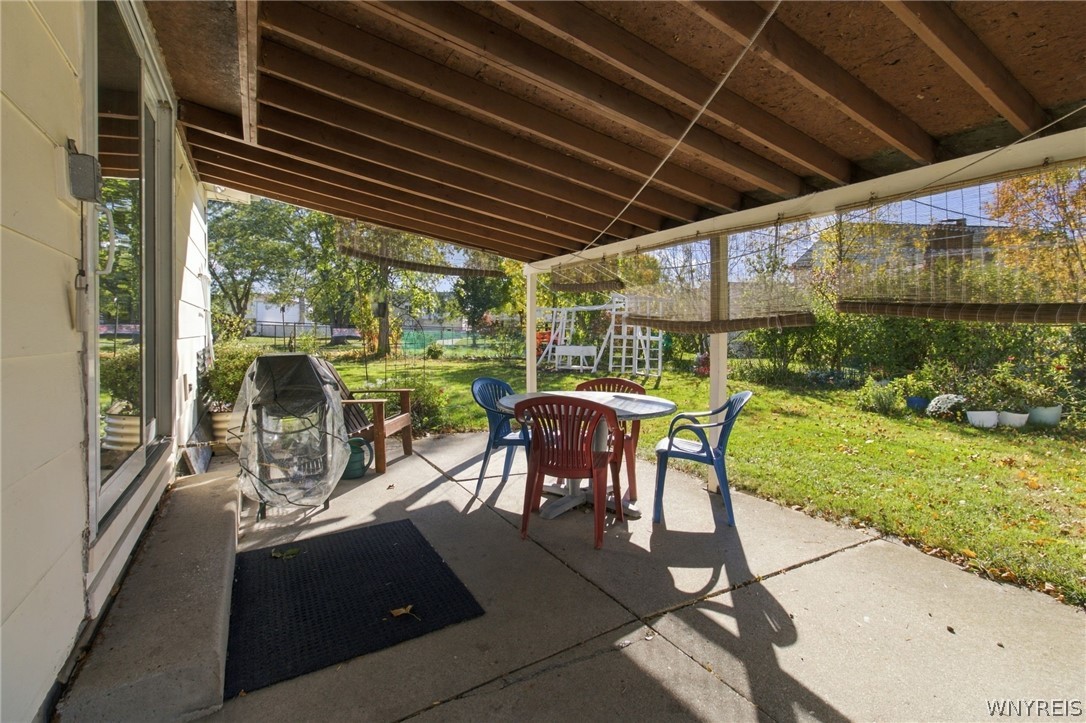 123 Ranch Trail West Amherst, NY 14221 - Photo 31 of 38 Shaded concrete patio opens directly to a lush, fully fenced yard surrounded by mature trees.