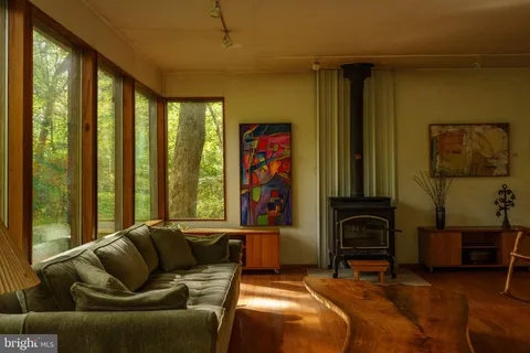a living room with large windows next to a yard