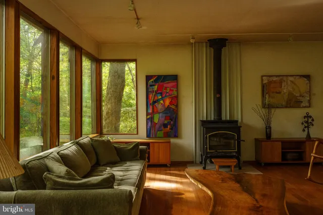 a living room with large windows next to a yard