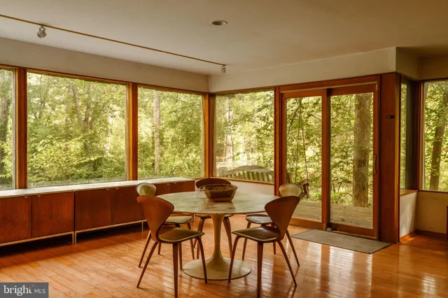 a living room with furniture pool table and large windows