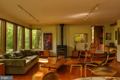 a view of a kitchen with kitchen island wooden floor and a sink