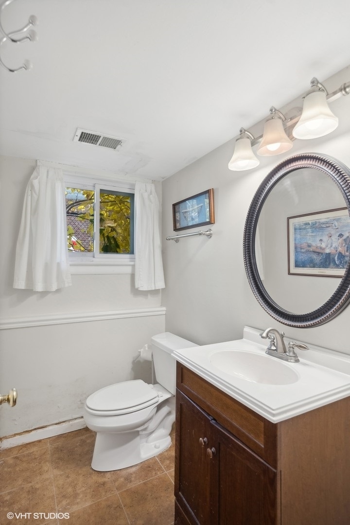 1521 Lakeside Drive Wheaton, IL 60187 - Photo 13 of 17 a bathroom with a toilet a sink and mirror