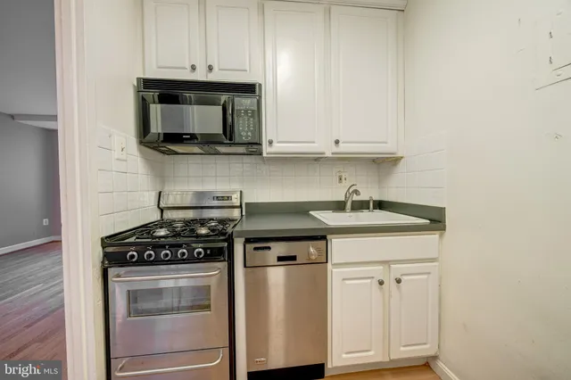a kitchen with stainless steel appliances granite countertop a sink stove and microwave