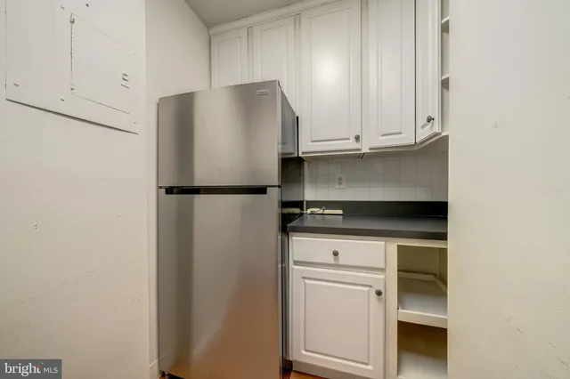 a kitchen with cabinets and a refrigerator