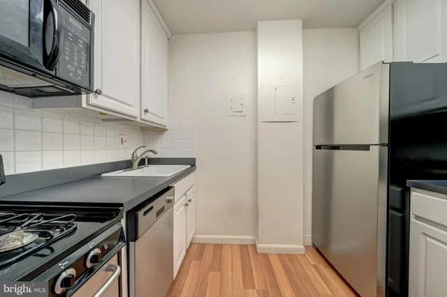 a kitchen with a sink a refrigerator and cabinets