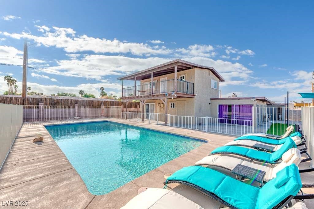 View of swimming pool featuring a balcony and a patio area