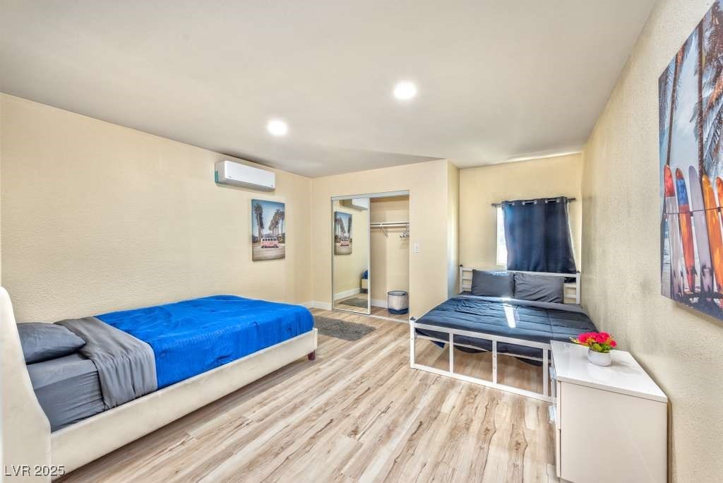 4990 Philmar Avenue Las Vegas, NV 89120 - Photo 27 of 32 Bedroom located in the back casita featuring light wood finished floors, a textured wall, recessed lighting, a closet, and a wall mounted AC