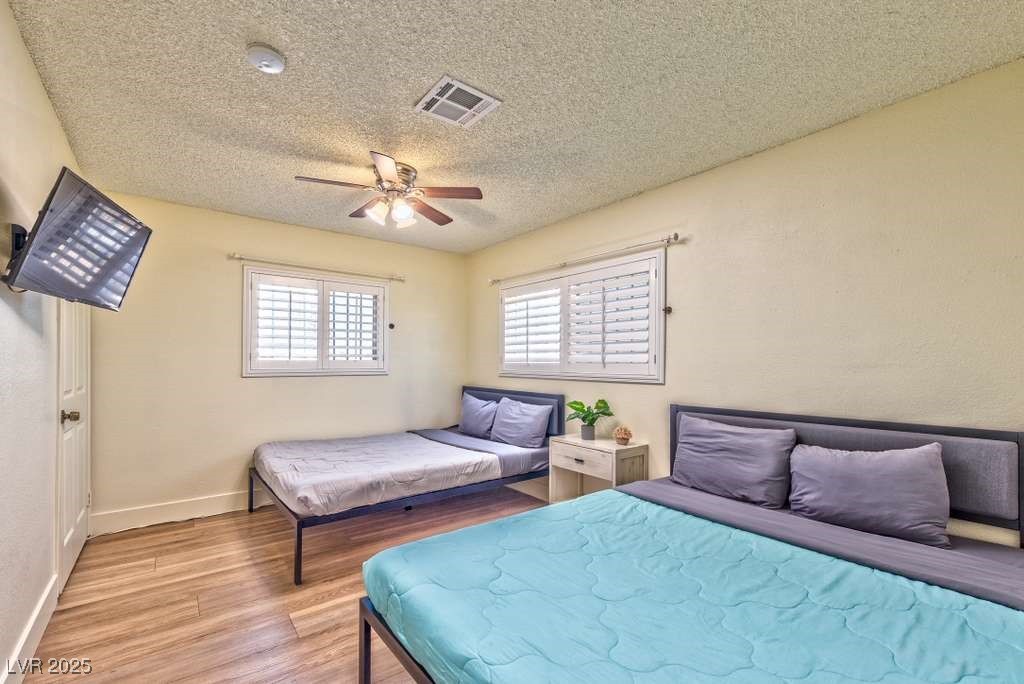 4990 Philmar Avenue Las Vegas, NV 89120 - Photo 8 of 32 Bedroom featuring light wood-type flooring, a textured ceiling, and a ceiling fan