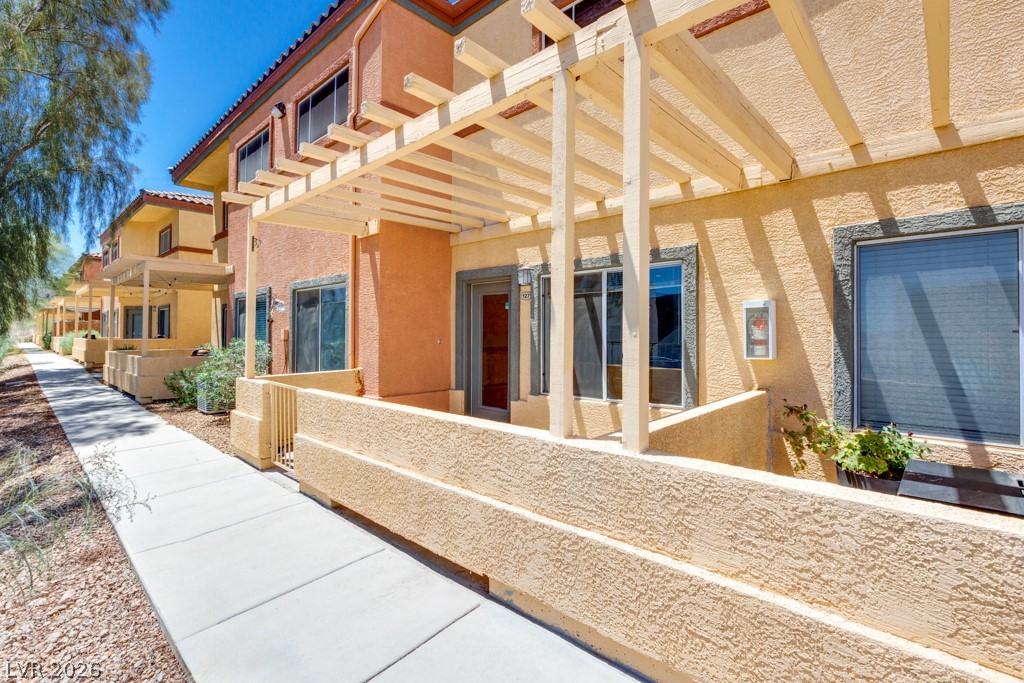 4915 East Russell Road, Unit 127 Las Vegas, NV 89120 - Photo 4 of 19 A row of charming stucco townhomes presents private front patios with wood pergolas.