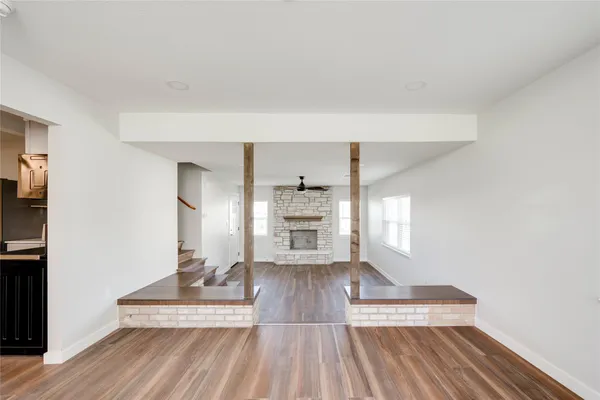 a view of a living room a wooden floor and a fireplace