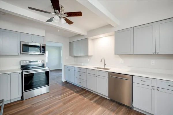 a kitchen with a sink stove and microwave