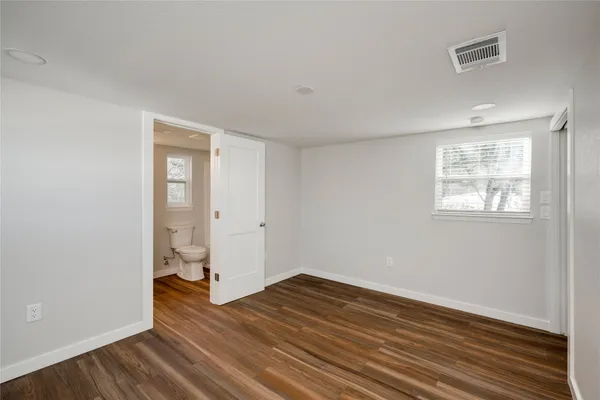 an empty room with wooden floor and a window