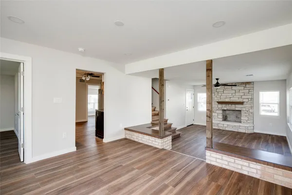 a view of a livingroom with wooden floor and staircase