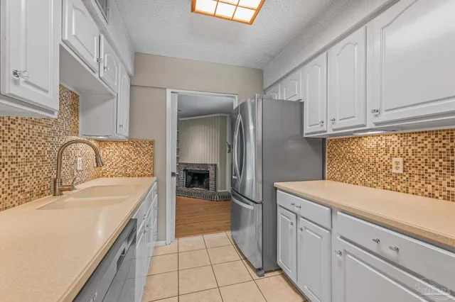 a kitchen with granite countertop a sink a stove and cabinets