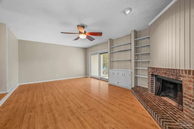 a view of an empty room with a fireplace and a window
