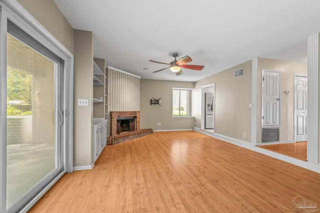 a view of a livingroom with a fireplace and window