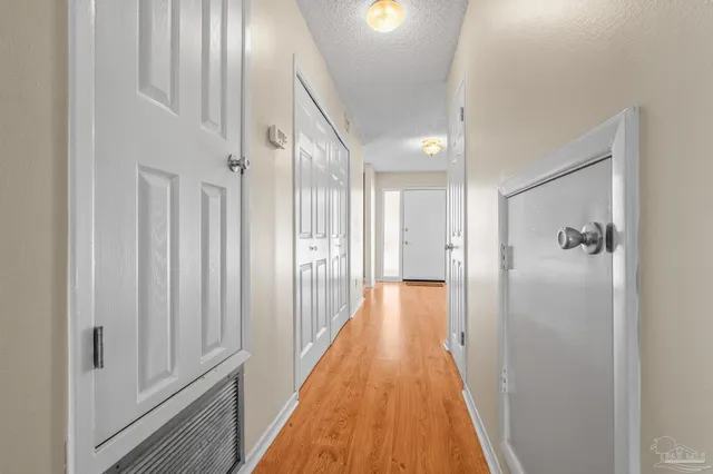 a view of a hallway with wooden floor and staircase