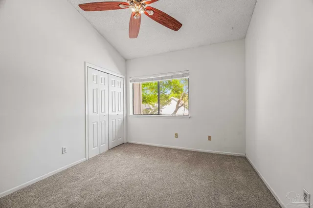 an empty room with windows and fan