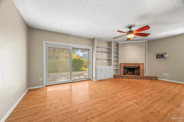 a view of an empty room with a fireplace and a window