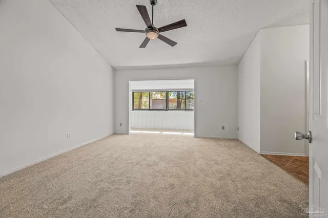 an empty room with fan and windows