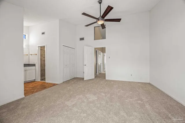 a view of a livingroom with a chandelier fan and refrigerator