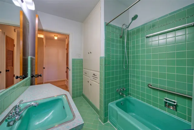 a bathroom with a tub a sink and washing machine