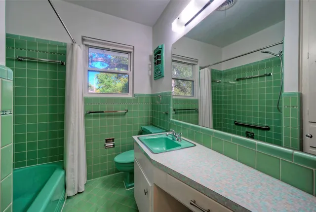 a bathroom with a sink mirror toilet and shower