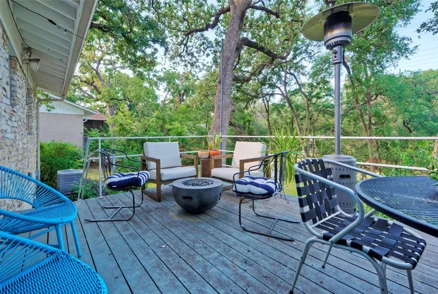 a view of a roof deck with table and chairs couches with wooden floor and fence