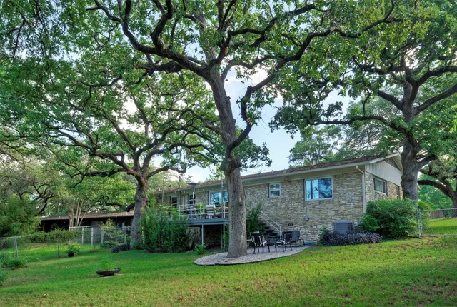 front view of a house with a yard and a large tree