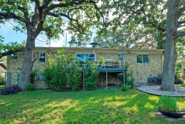 a view of house with back yard and a garden