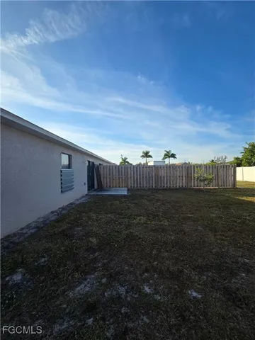 a view of yard with large tree and wooden fence