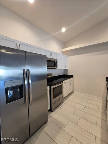 a kitchen with stainless steel appliances granite countertop a sink and a refrigerator