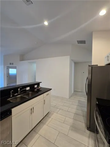 a view of a kitchen with a sink and a refrigerator