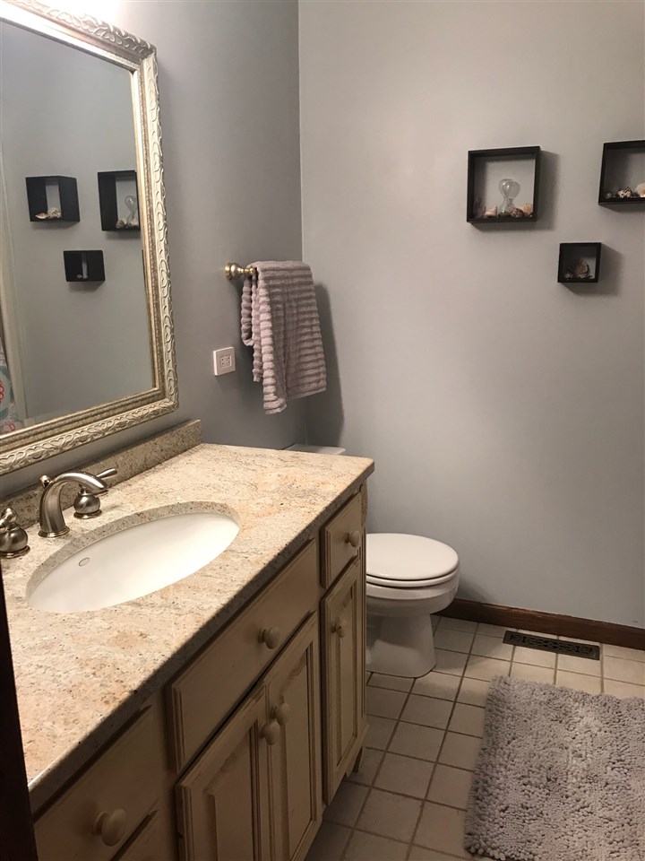 810 East Old Wagon Road Byron, IL 61010 - Photo 16 of 25 a bathroom with a granite countertop sink and a mirror