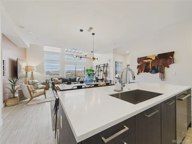 a kitchen with a sink a counter and chairs