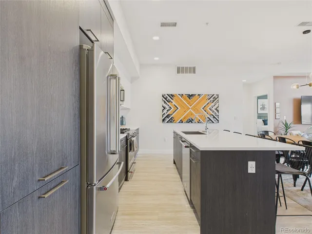 a kitchen with stainless steel appliances granite countertop a sink and a refrigerator